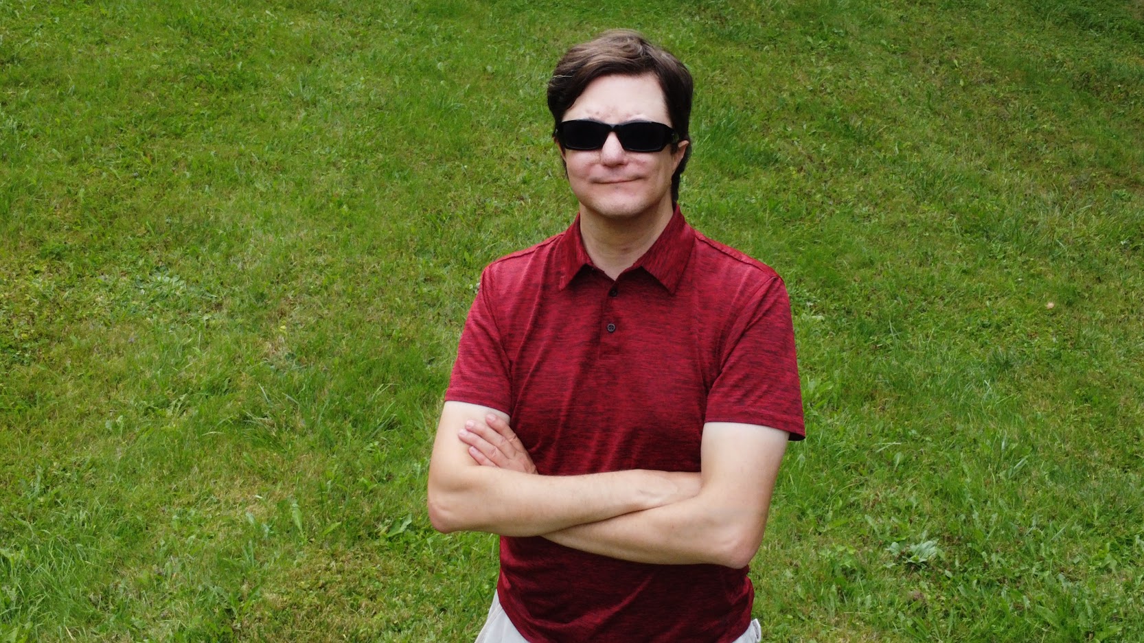 photo of Don Miasek. He is wearing a red shirt and standing in a green field. 